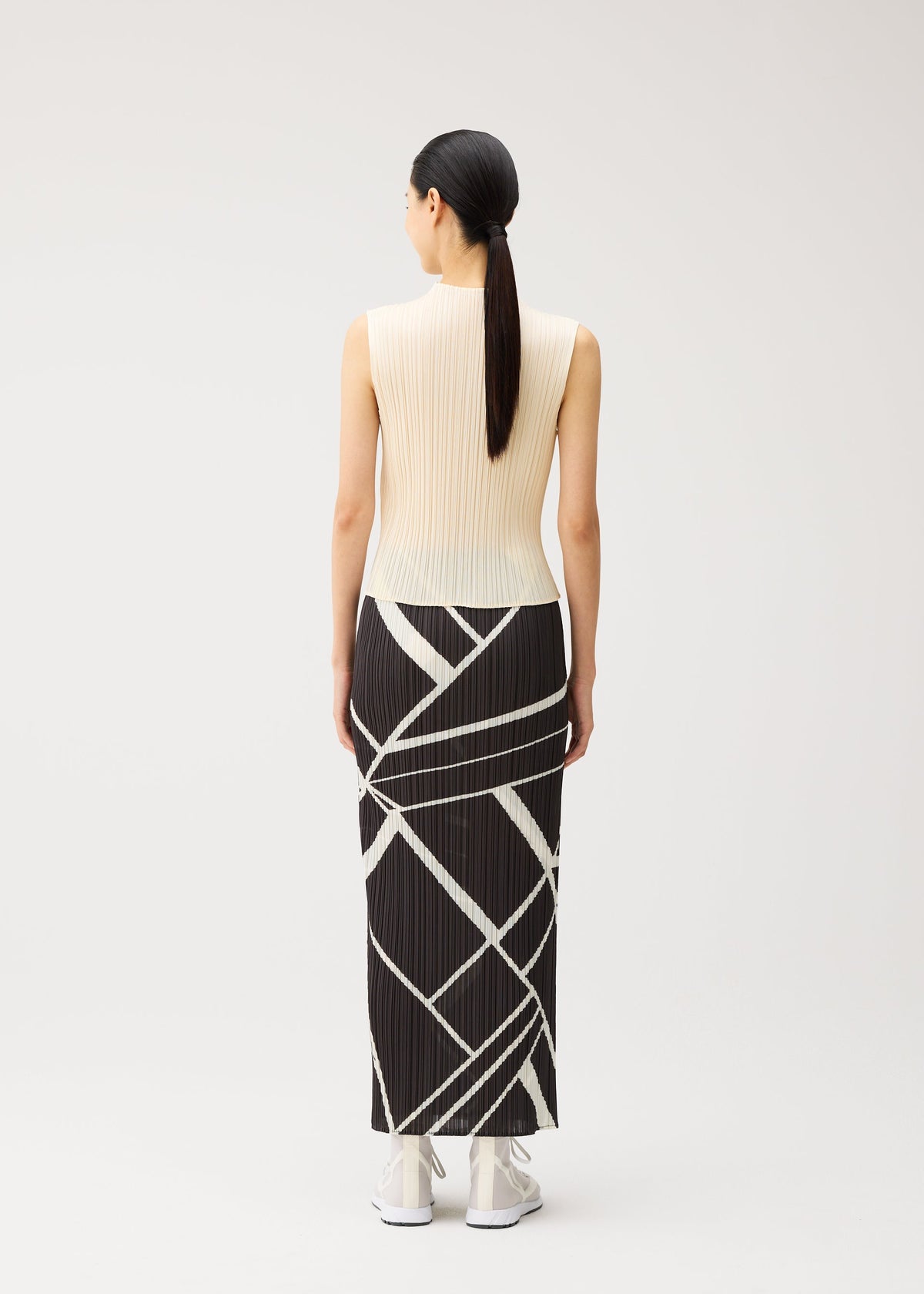 A model wears the PLEATS PLEASE ISSEY MIYAKE FOLD LINE fold-line-skirt-charcoal.
