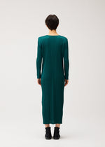 A model wears the PLEATS PLEASE ISSEY MIYAKE MONTHLY COLORS : OCTOBER monthly-colors-october-midi-dress-yellow-ochre.