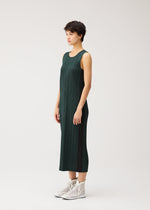 A model wears the PLEATS PLEASE ISSEY MIYAKE COTTON DENIM cotton-denim-dress-dark-green.