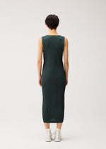 A model wears the PLEATS PLEASE ISSEY MIYAKE COTTON DENIM cotton-denim-dress-dark-green.