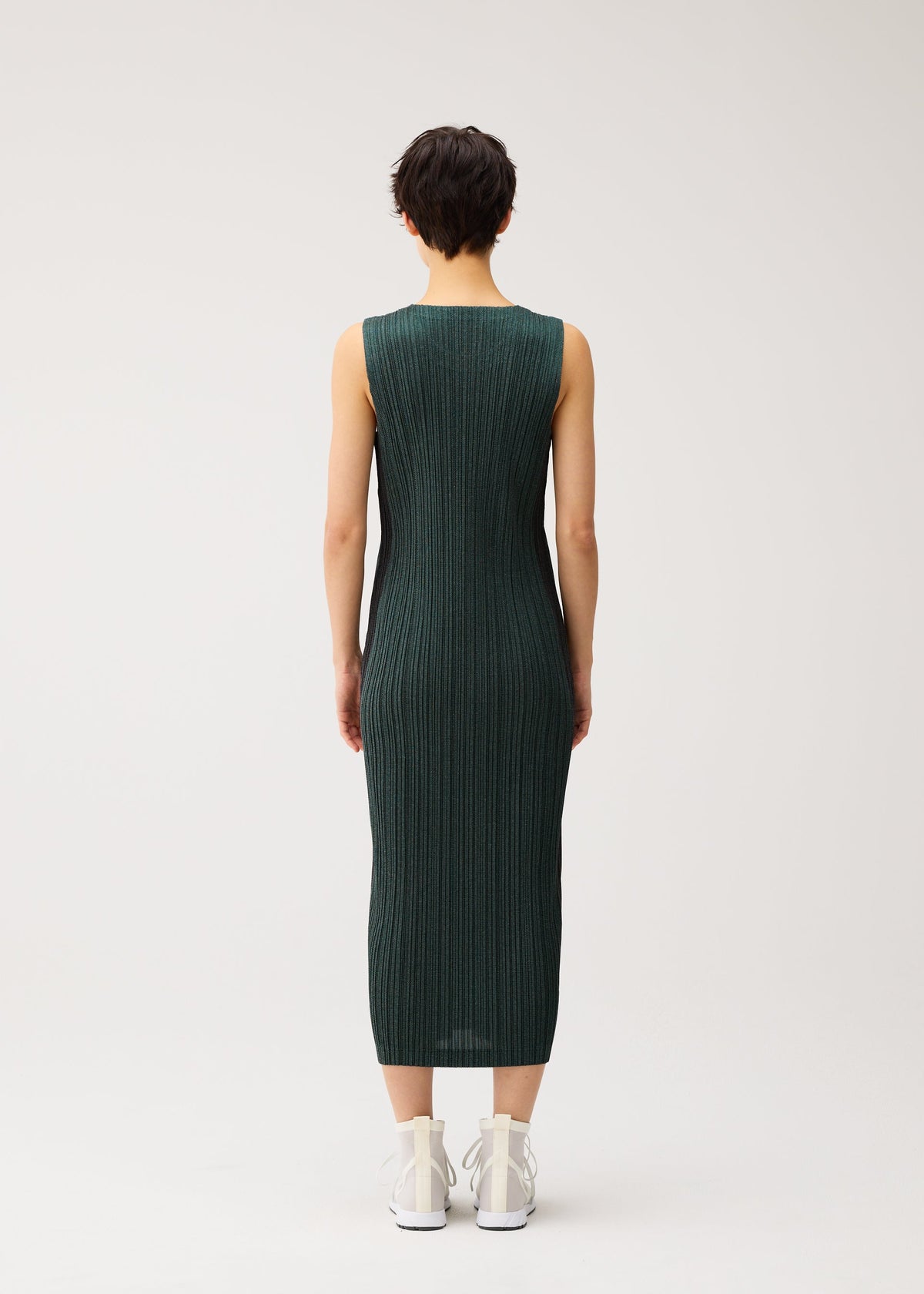 A model wears the PLEATS PLEASE ISSEY MIYAKE COTTON DENIM cotton-denim-dress-dark-green.