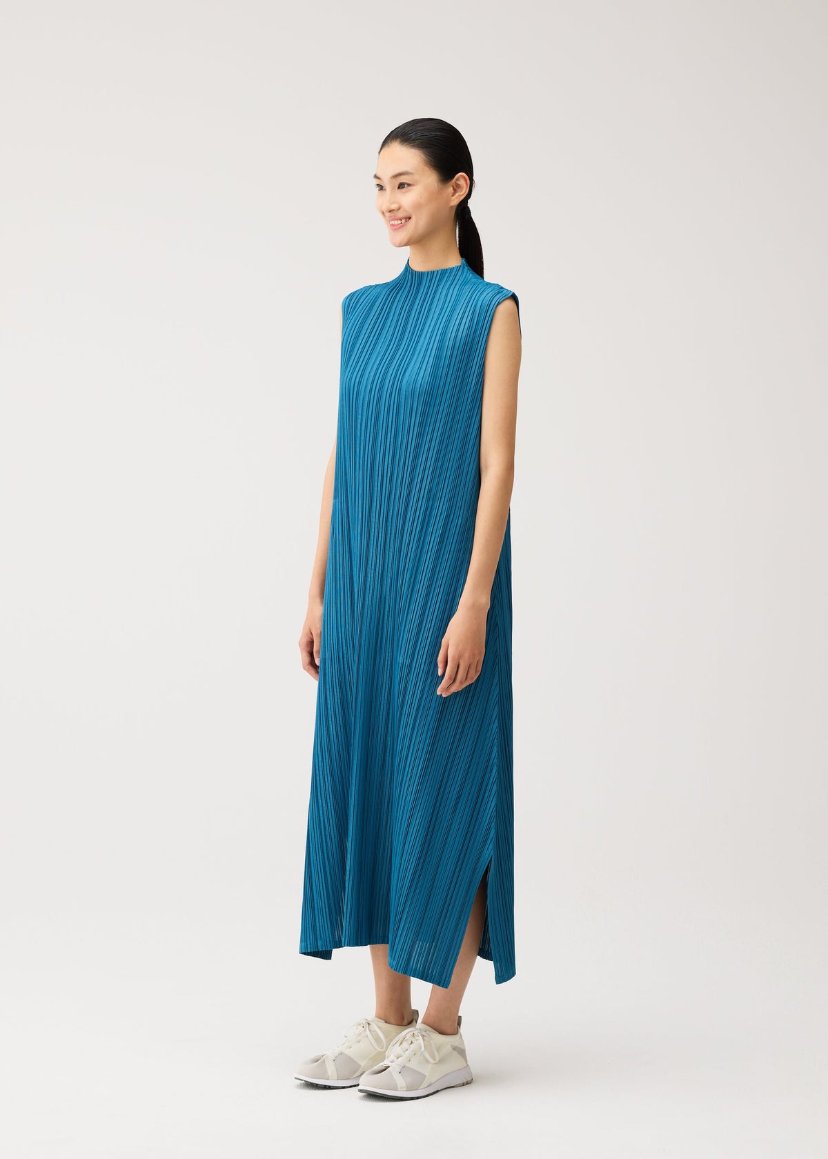 A model wears the PLEATS PLEASE ISSEY MIYAKE MELLOW PLEATS mellow-pleats-sleeveless-dress-charcoal.