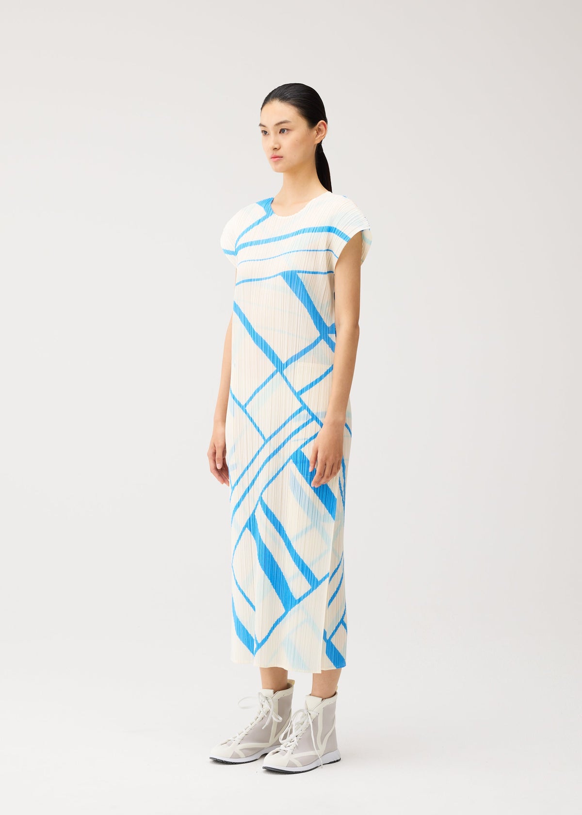 A model wears the PLEATS PLEASE ISSEY MIYAKE FOLD LINE fold-line-dress-off-white.
