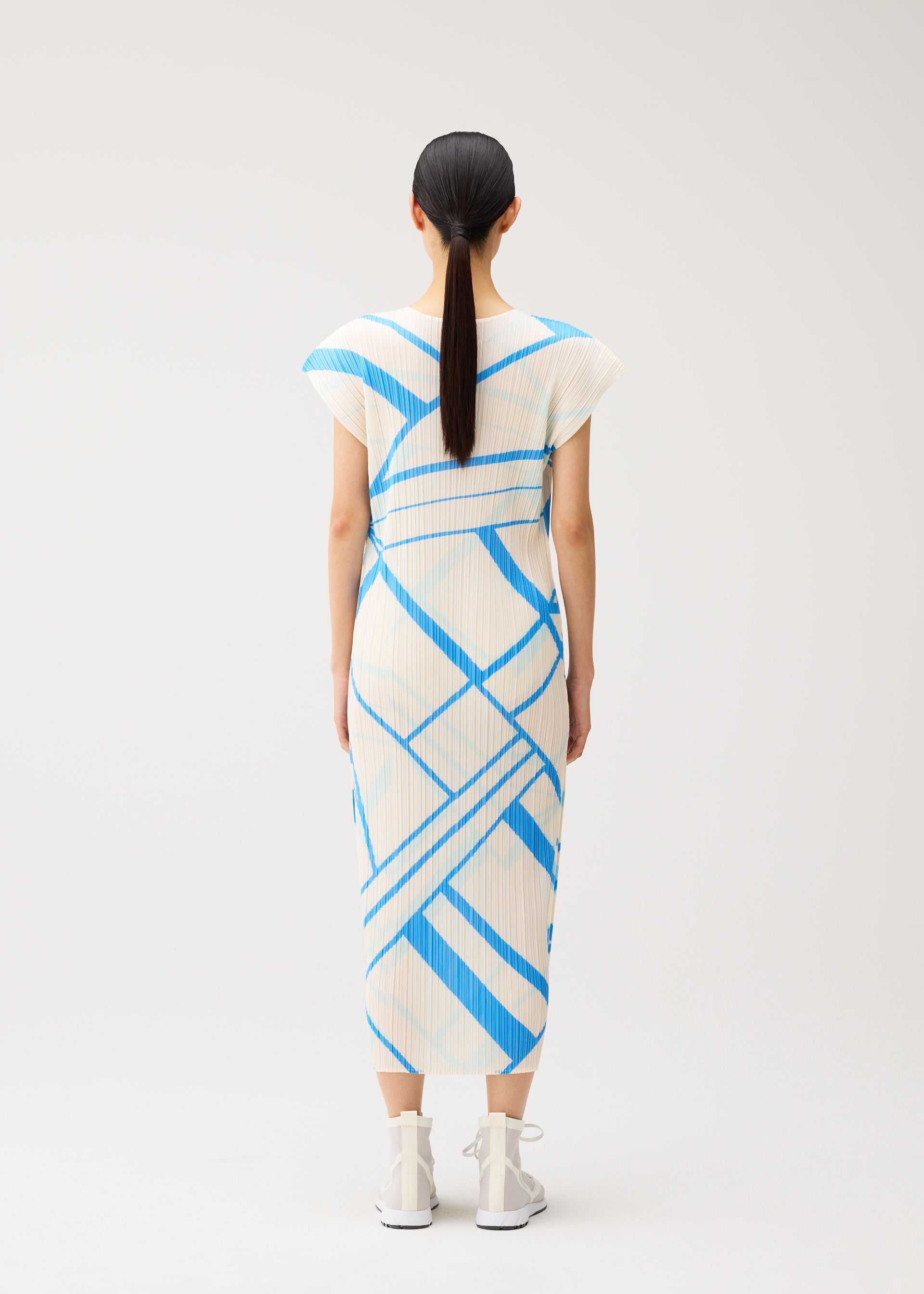 A model wears the PLEATS PLEASE ISSEY MIYAKE FOLD LINE fold-line-dress-off-white.
