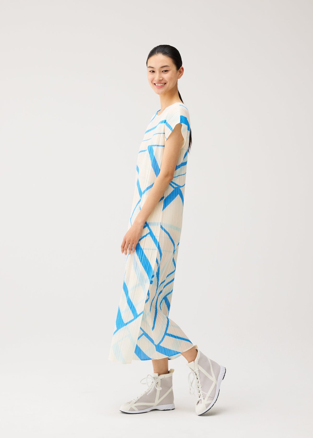 A model wears the PLEATS PLEASE ISSEY MIYAKE FOLD LINE fold-line-dress-off-white.