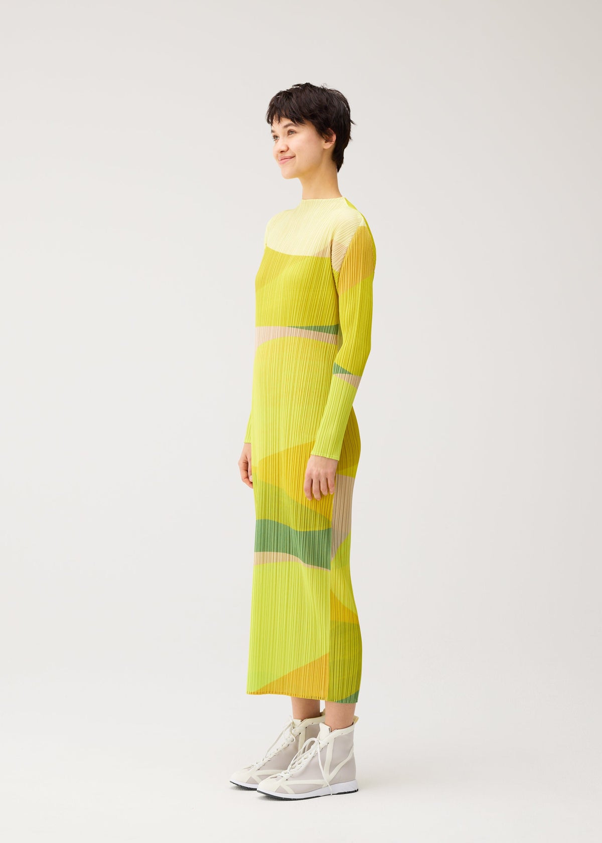 A model wears the PLEATS PLEASE ISSEY MIYAKE ORBIT orbit-dress-yellow.