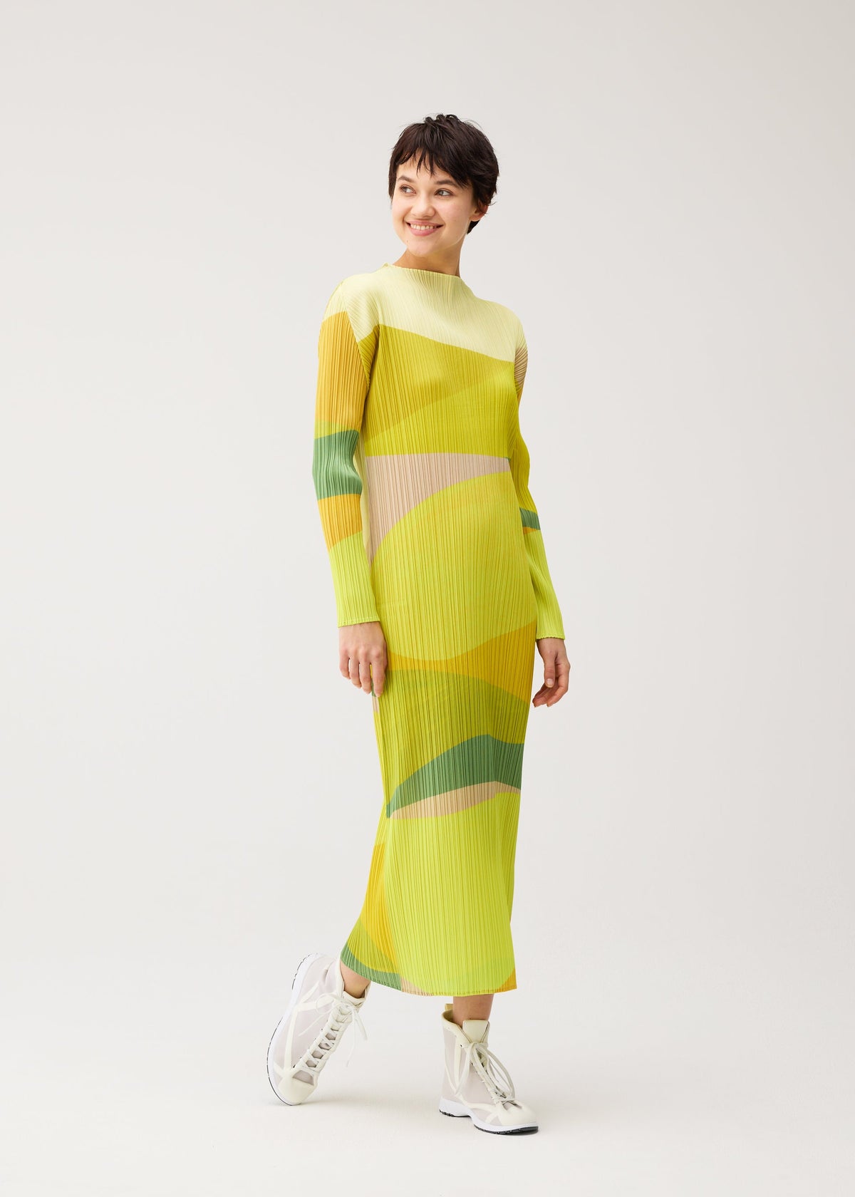 A model wears the PLEATS PLEASE ISSEY MIYAKE ORBIT orbit-dress-green.