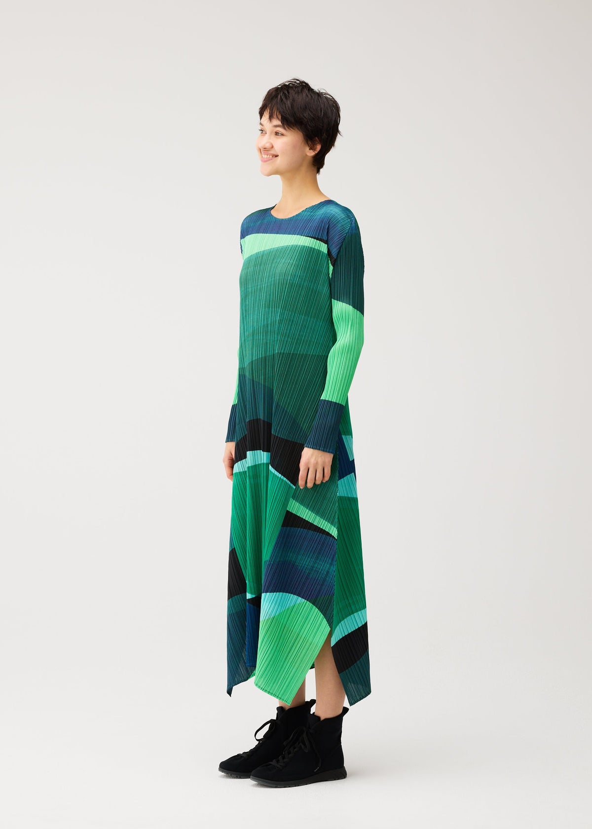 A model wears the PLEATS PLEASE ISSEY MIYAKE ORBIT orbit-a-line-dress-green.