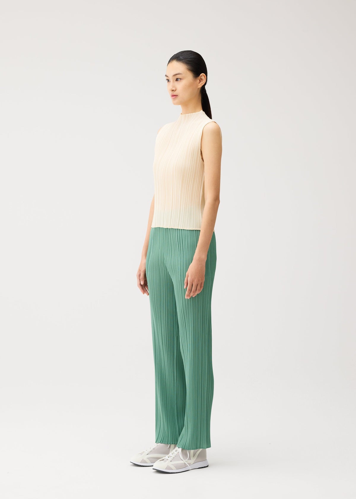 A model wears the PLEATS PLEASE ISSEY MIYAKE MONTHLY COLORS : AUGUST monthly-colors-august-high-neck-top-light-blue.