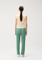 A model wears the PLEATS PLEASE ISSEY MIYAKE MONTHLY COLORS : AUGUST monthly-colors-august-top-greyish-green.
