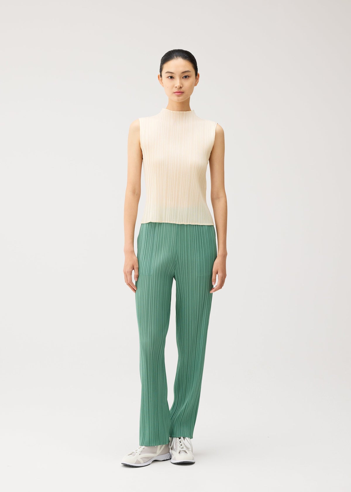 A model wears the PLEATS PLEASE ISSEY MIYAKE MONTHLY COLORS : AUGUST monthly-colors-august-top-off-white.