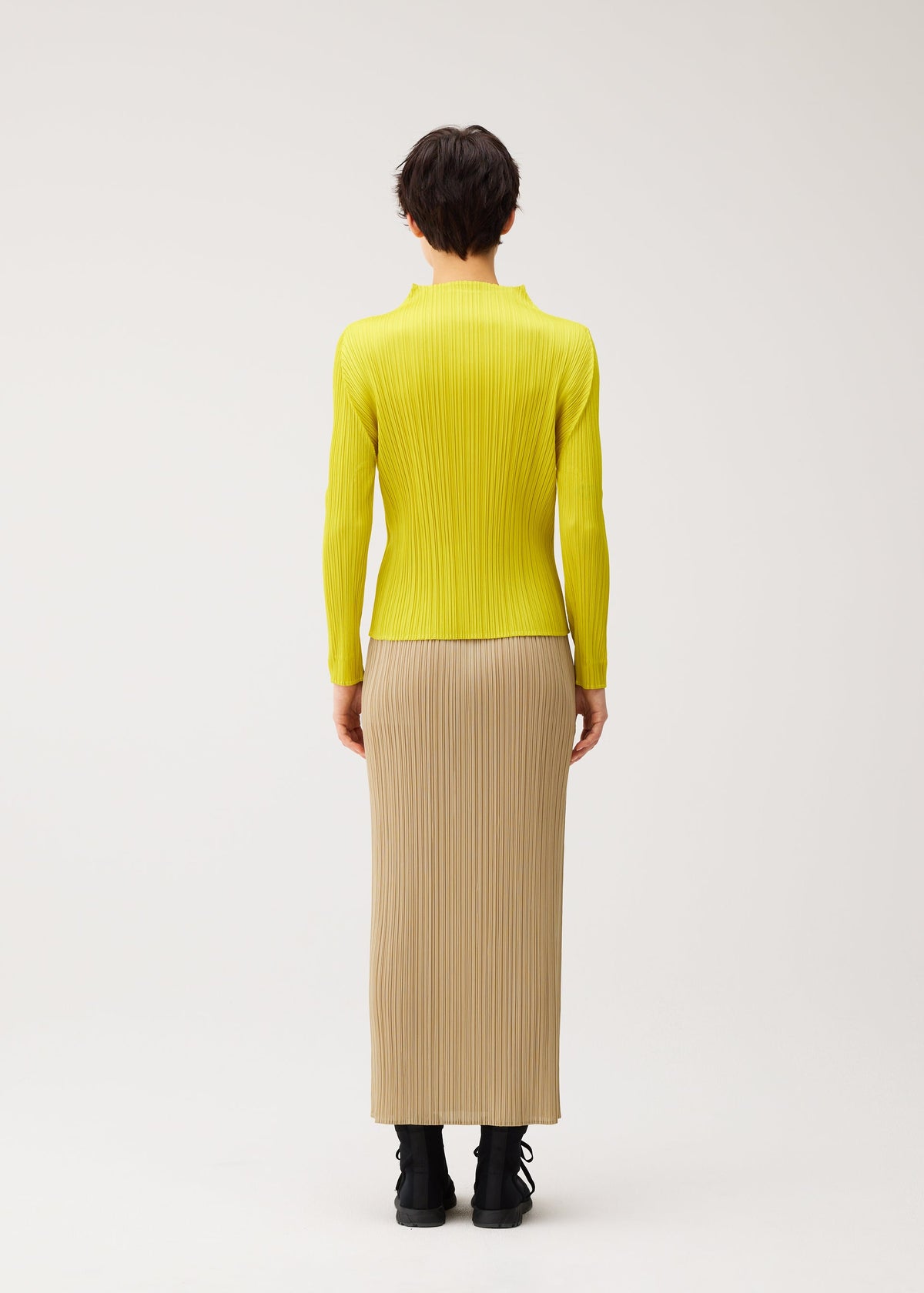 A model wears the PLEATS PLEASE ISSEY MIYAKE MONTHLY COLORS : OCTOBER monthly-colors-october-long-sleeved-top-yellow-ochre.