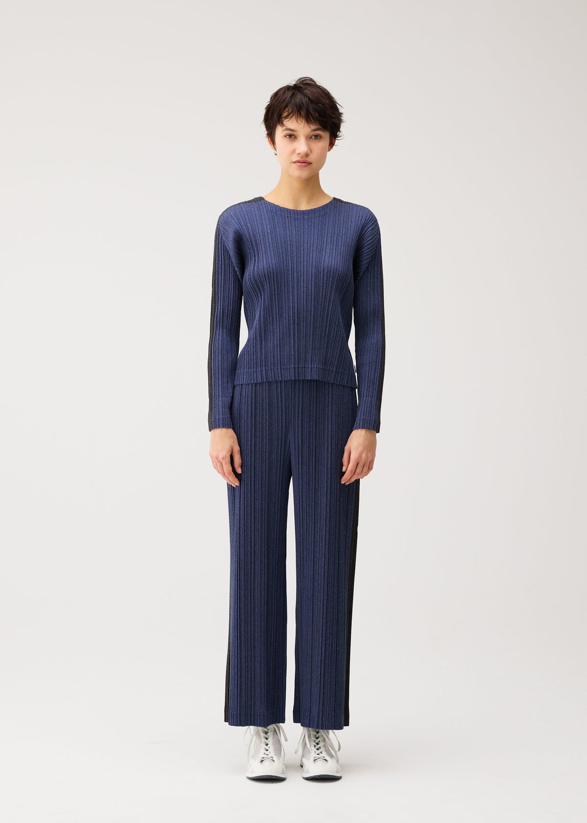 A model wears the PLEATS PLEASE ISSEY MIYAKE COTTON DENIM cotton-denim-top-dark-green.