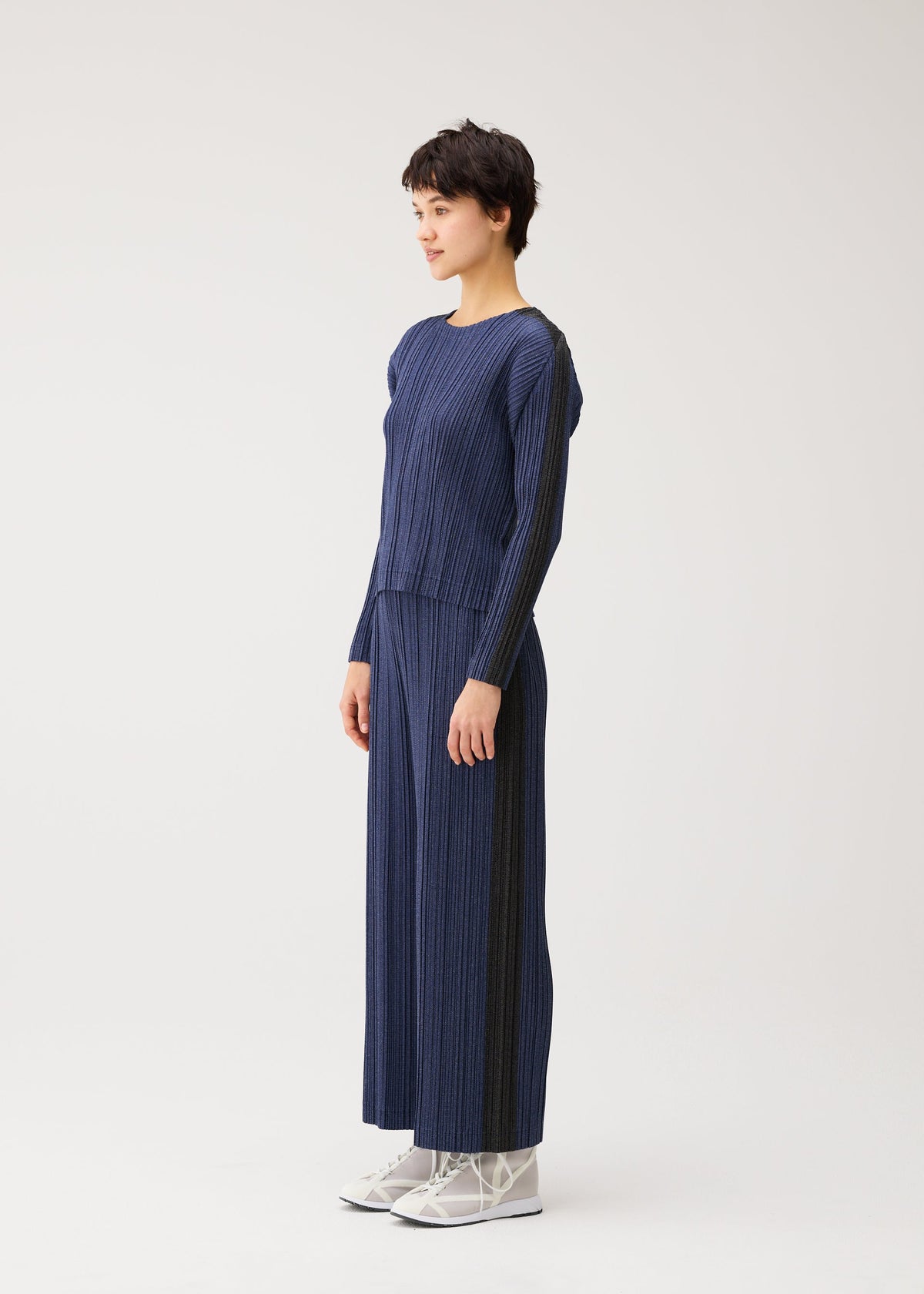 A model wears the PLEATS PLEASE ISSEY MIYAKE COTTON DENIM cotton-denim-top-dark-green.