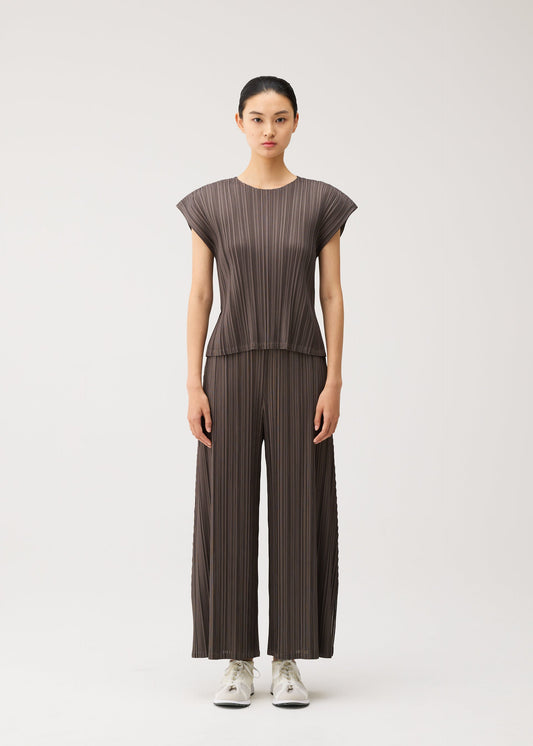 A model wears the PLEATS PLEASE ISSEY MIYAKE MELLOW PLEATS mellow-pleats-cap-sleeved-top-black.