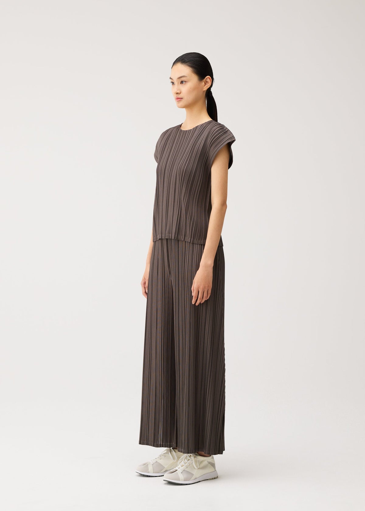 A model wears the PLEATS PLEASE ISSEY MIYAKE MELLOW PLEATS mellow-pleats-cap-sleeved-top-black.