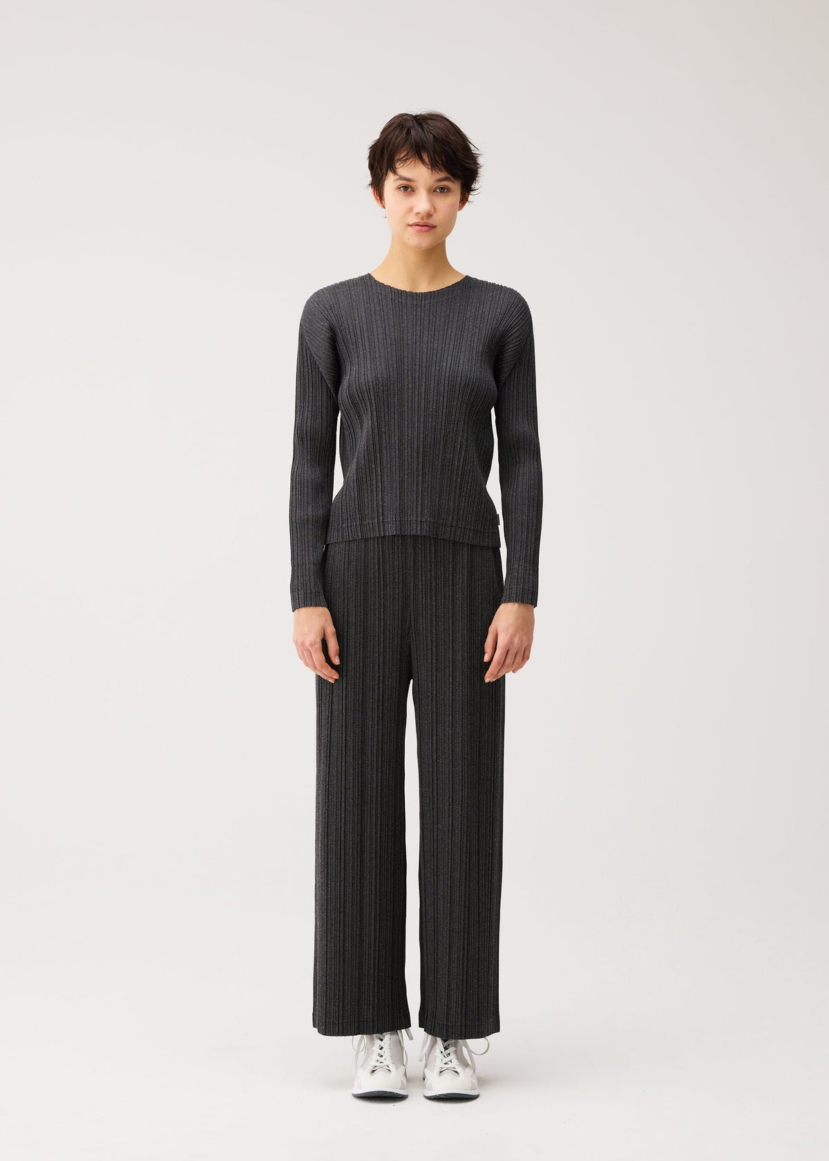 A model wears the PLEATS PLEASE ISSEY MIYAKE COTTON DENIM BLACK cotton-denim-black-top-black.