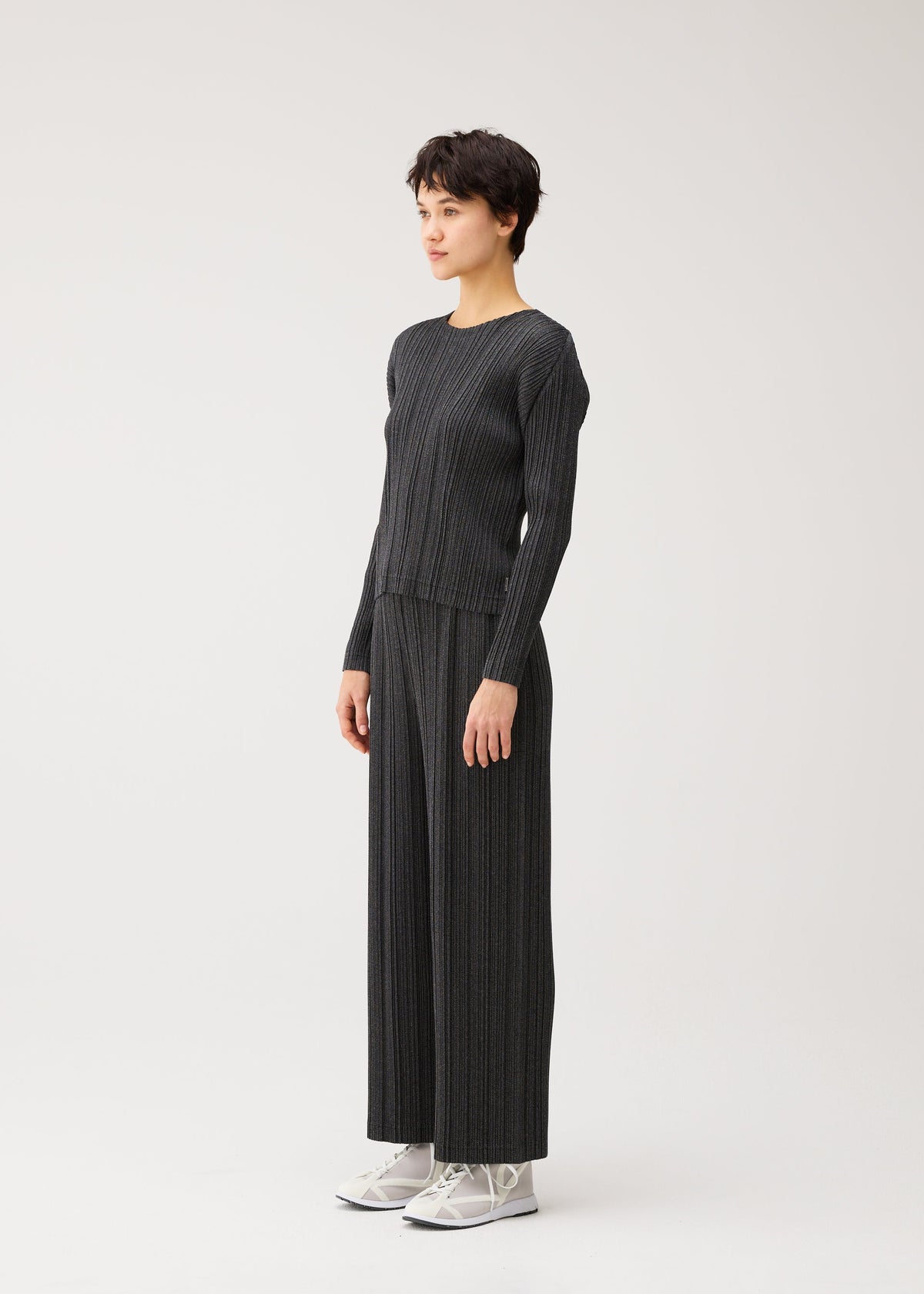 A model wears the PLEATS PLEASE ISSEY MIYAKE COTTON DENIM BLACK cotton-denim-black-top-black.