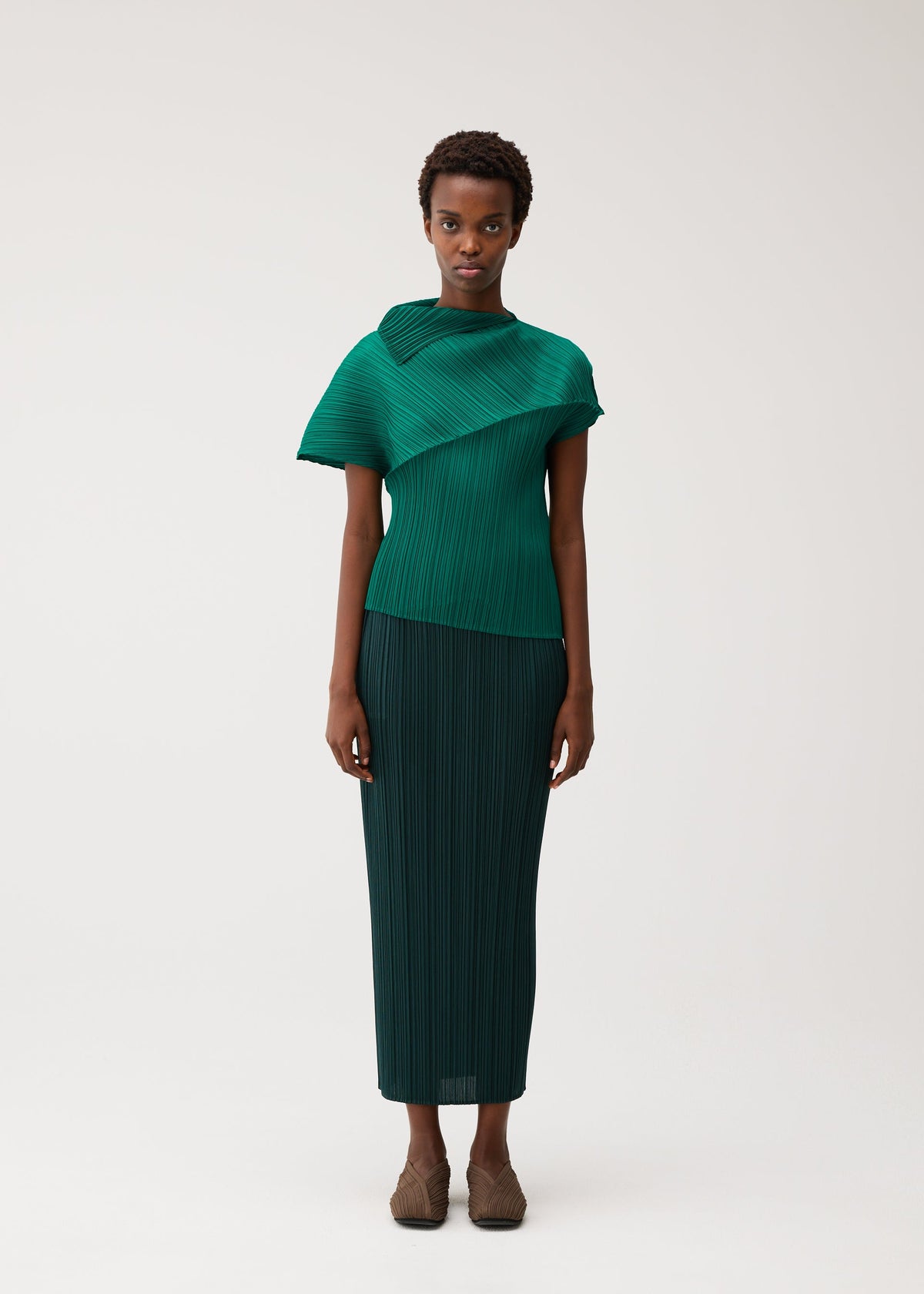 A model wears the PLEATS PLEASE ISSEY MIYAKE LEAP leap-top-black.