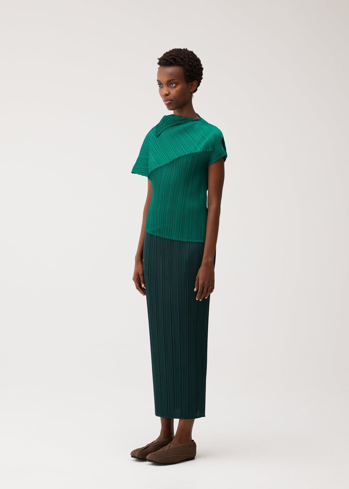 A model wears the PLEATS PLEASE ISSEY MIYAKE LEAP leap-top-black.