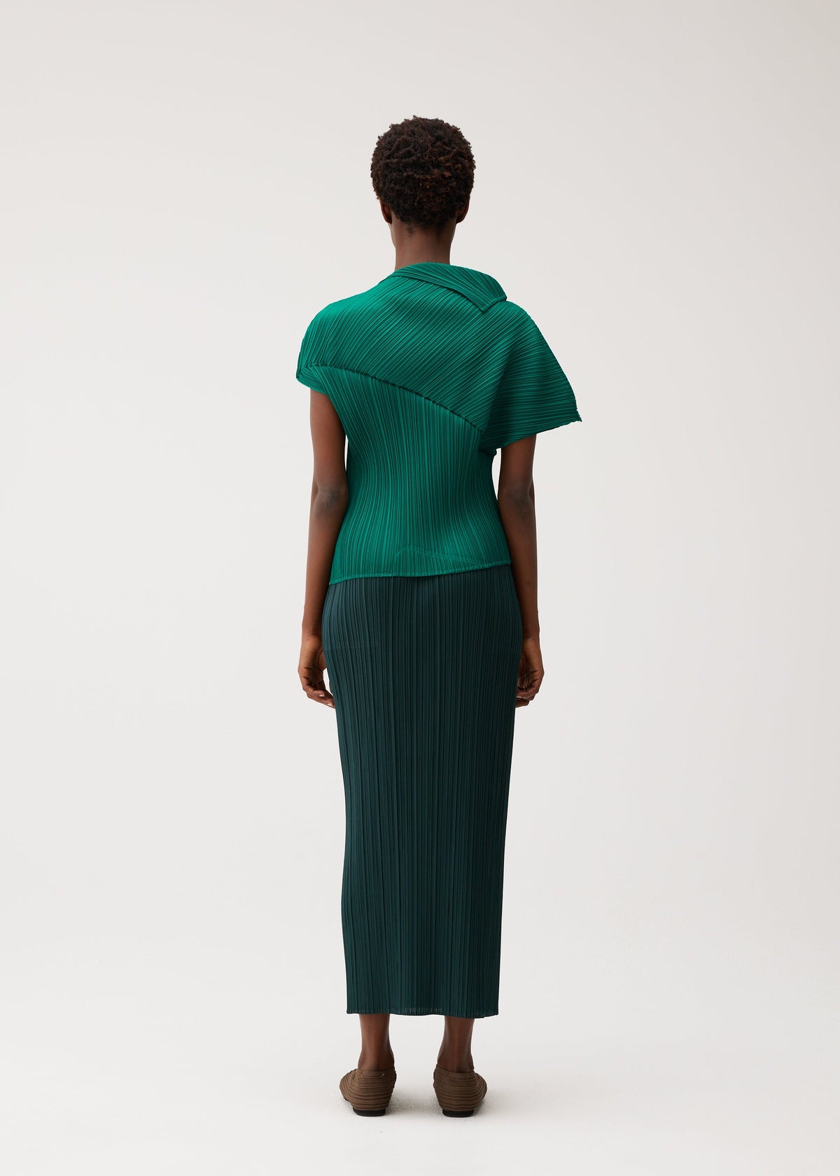 A model wears the PLEATS PLEASE ISSEY MIYAKE LEAP leap-top-black.
