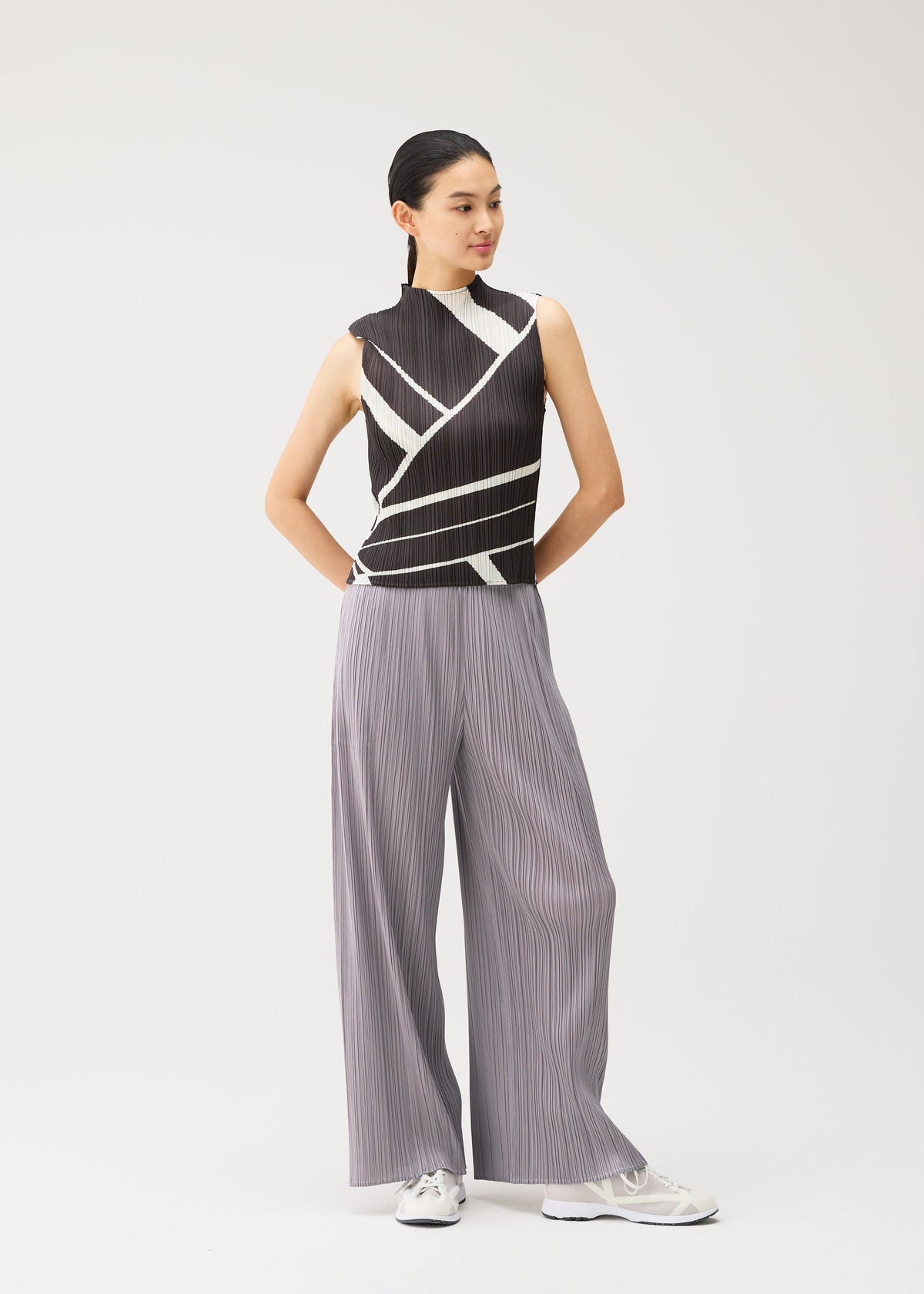 A model wears the PLEATS PLEASE ISSEY MIYAKE FOLD LINE fold-line-top-off-white.