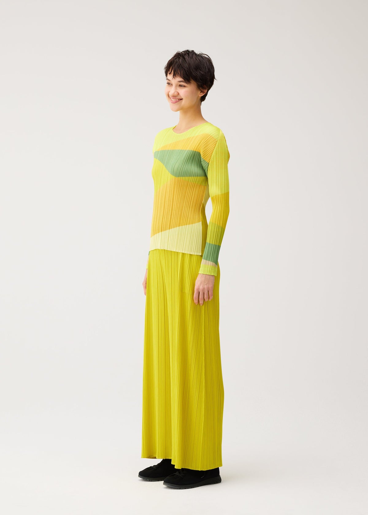 A model wears the PLEATS PLEASE ISSEY MIYAKE ORBIT orbit-top-green.