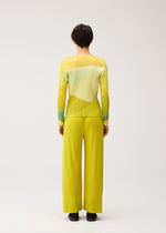 A model wears the PLEATS PLEASE ISSEY MIYAKE ORBIT orbit-top-green.