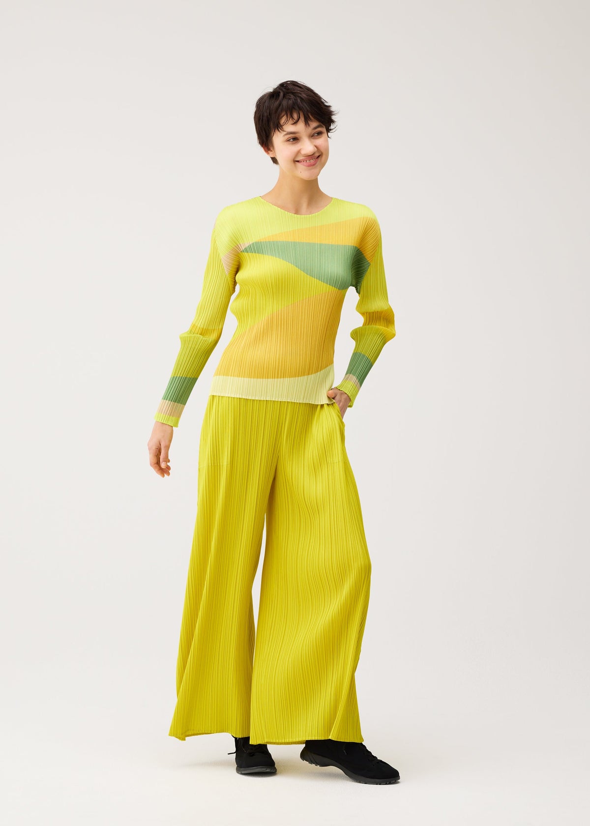 A model wears the PLEATS PLEASE ISSEY MIYAKE ORBIT orbit-top-green.