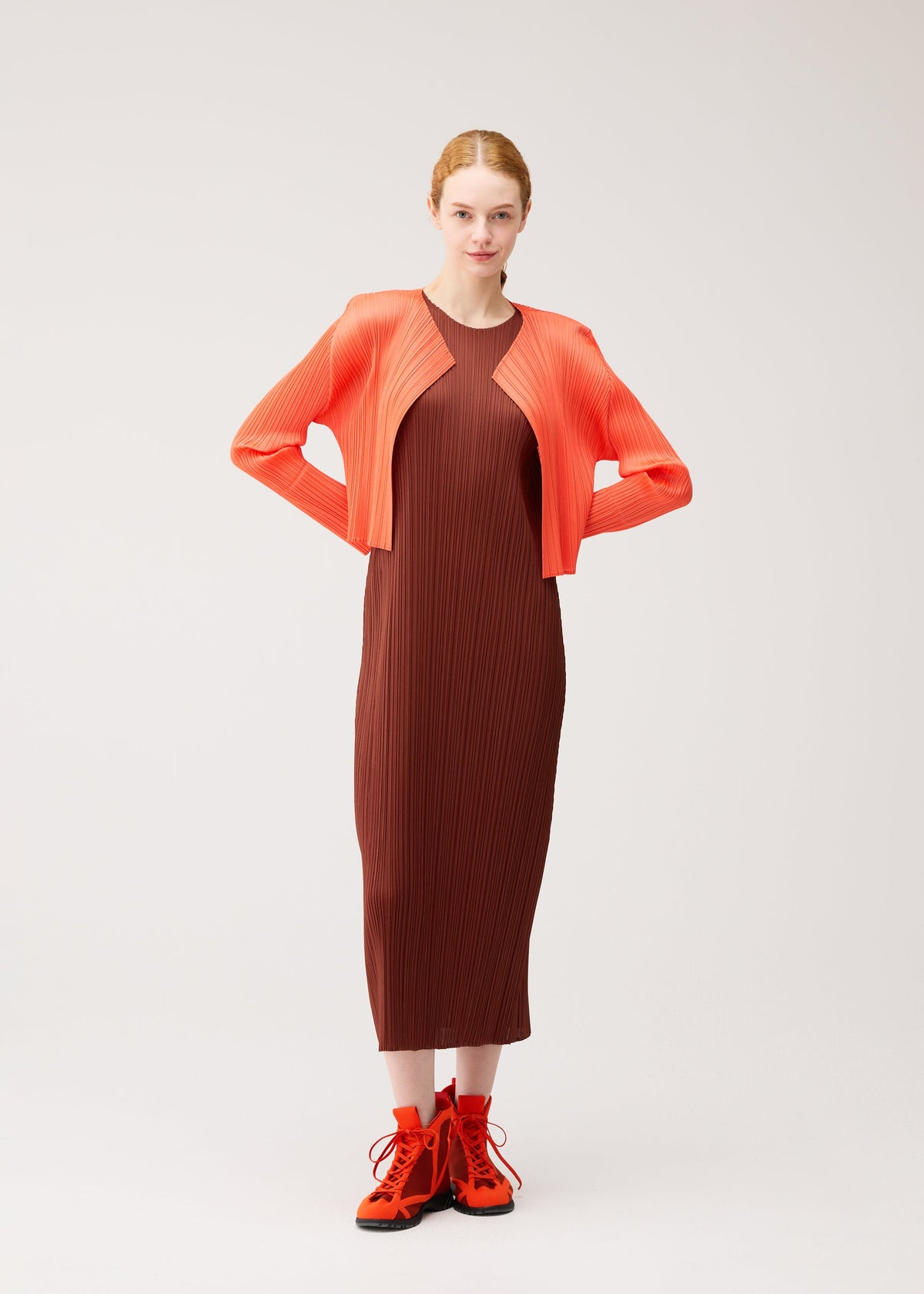 A model wears the PLEATS PLEASE ISSEY MIYAKE MONTHLY COLORS : SEPTEMBER monthly-colors-september-cardigan-red-brown.