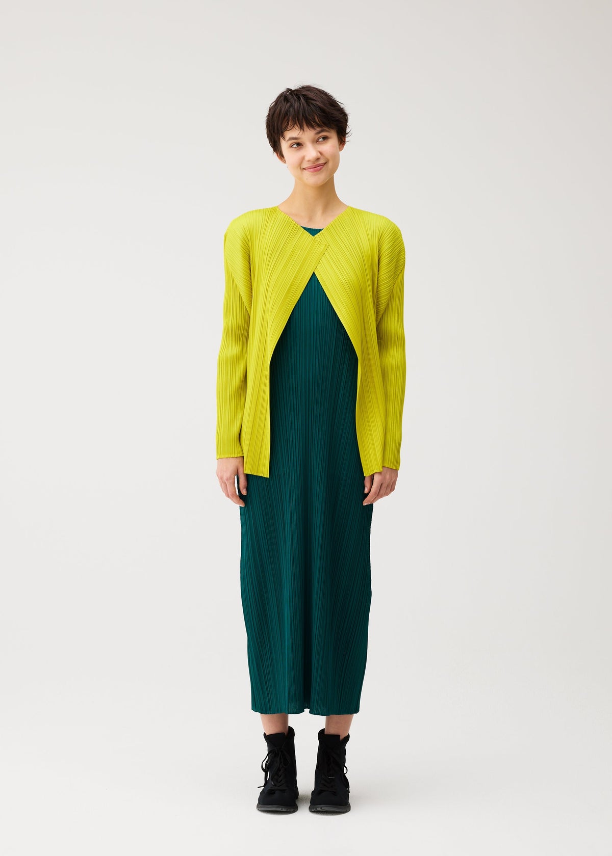 A model wears the PLEATS PLEASE ISSEY MIYAKE MONTHLY COLORS : OCTOBER monthly-colors-october-cardigan-yellow-ochre.