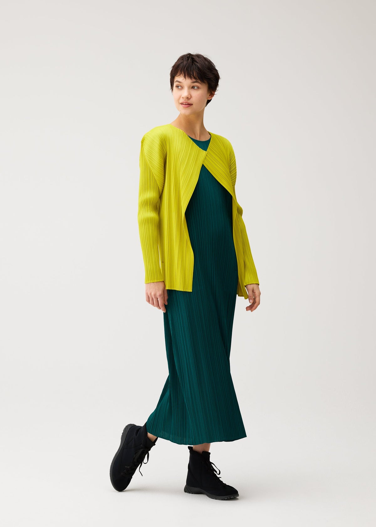 A model wears the PLEATS PLEASE ISSEY MIYAKE MONTHLY COLORS : OCTOBER monthly-colors-october-cardigan-dark-green.