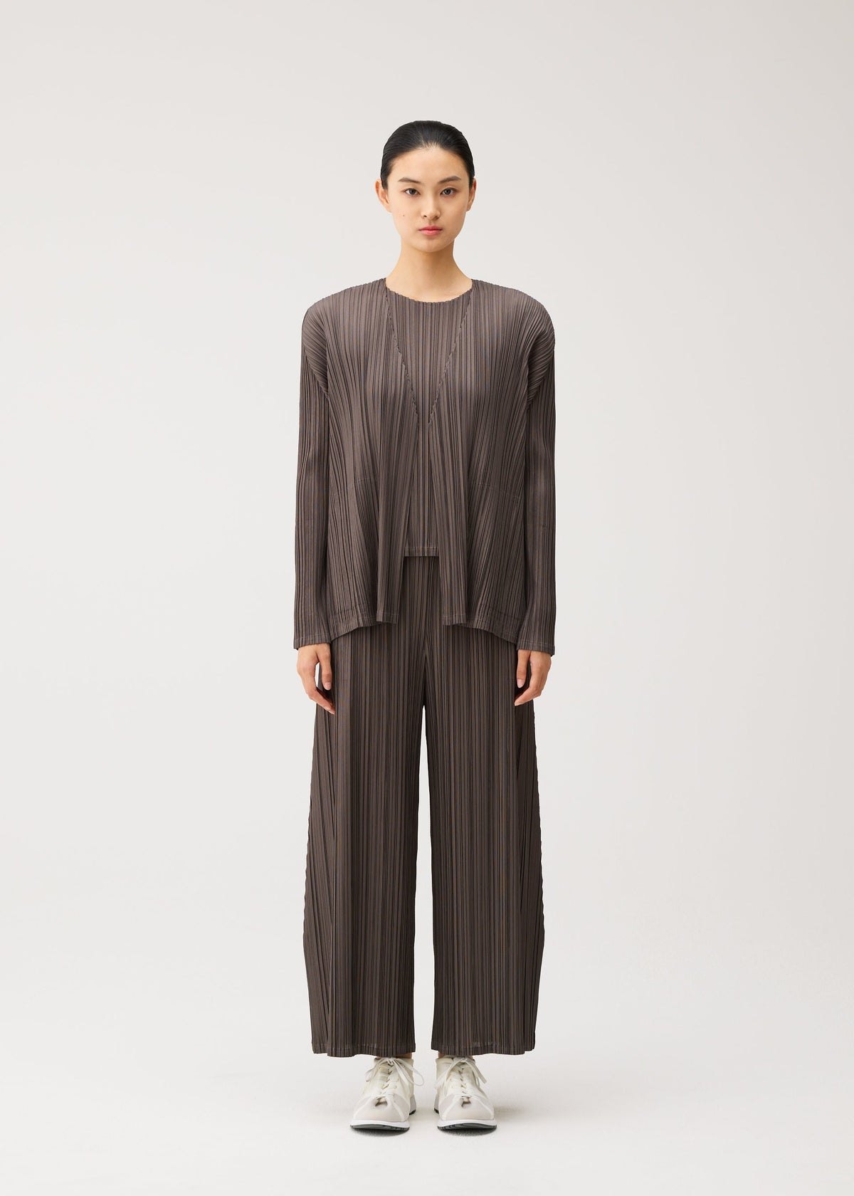 A model wears the PLEATS PLEASE ISSEY MIYAKE MELLOW PLEATS mellow-pleats-cardigan-cerulean-blue.