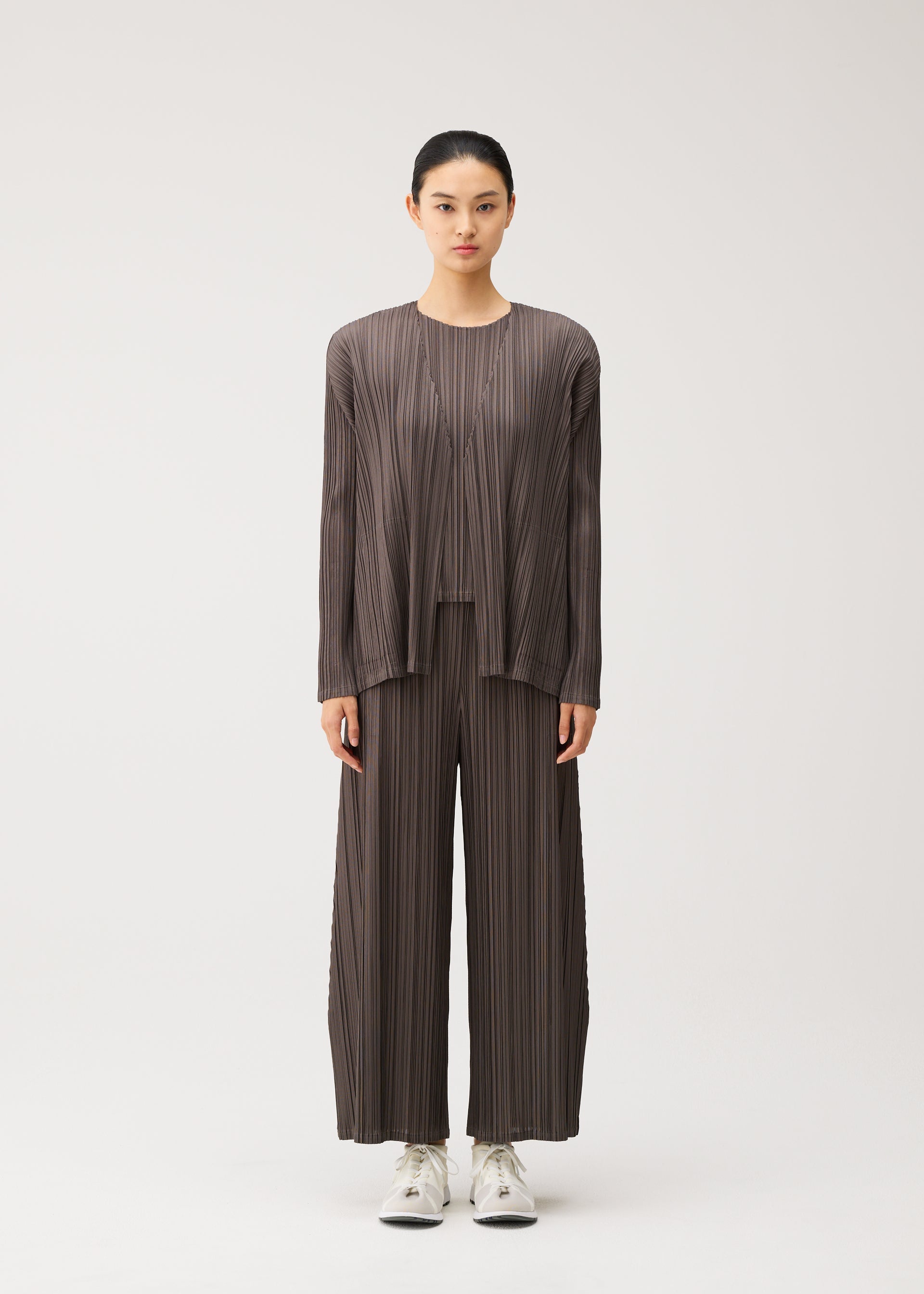 A model wears the PLEATS PLEASE ISSEY MIYAKE MELLOW PLEATS mellow-pleats-cardigan-cerulean-blue.