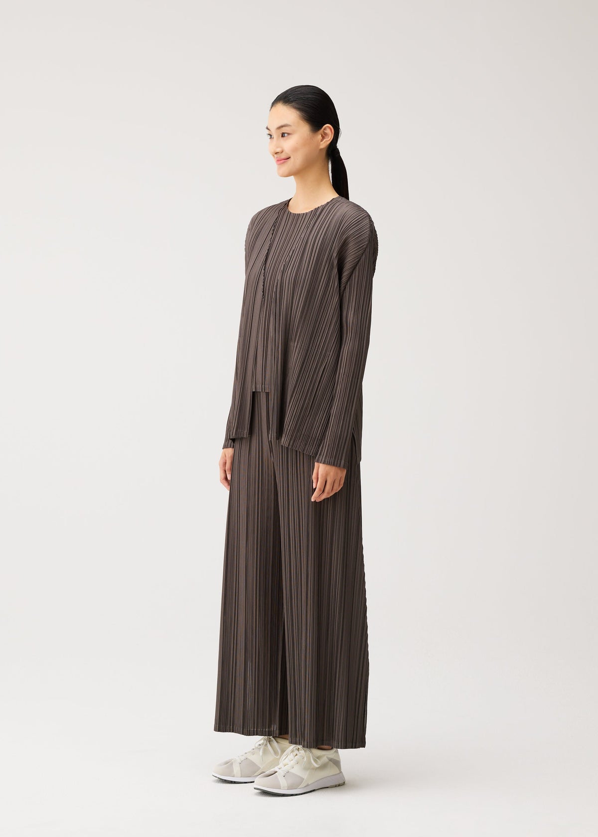 A model wears the PLEATS PLEASE ISSEY MIYAKE MELLOW PLEATS mellow-pleats-cardigan-cerulean-blue.