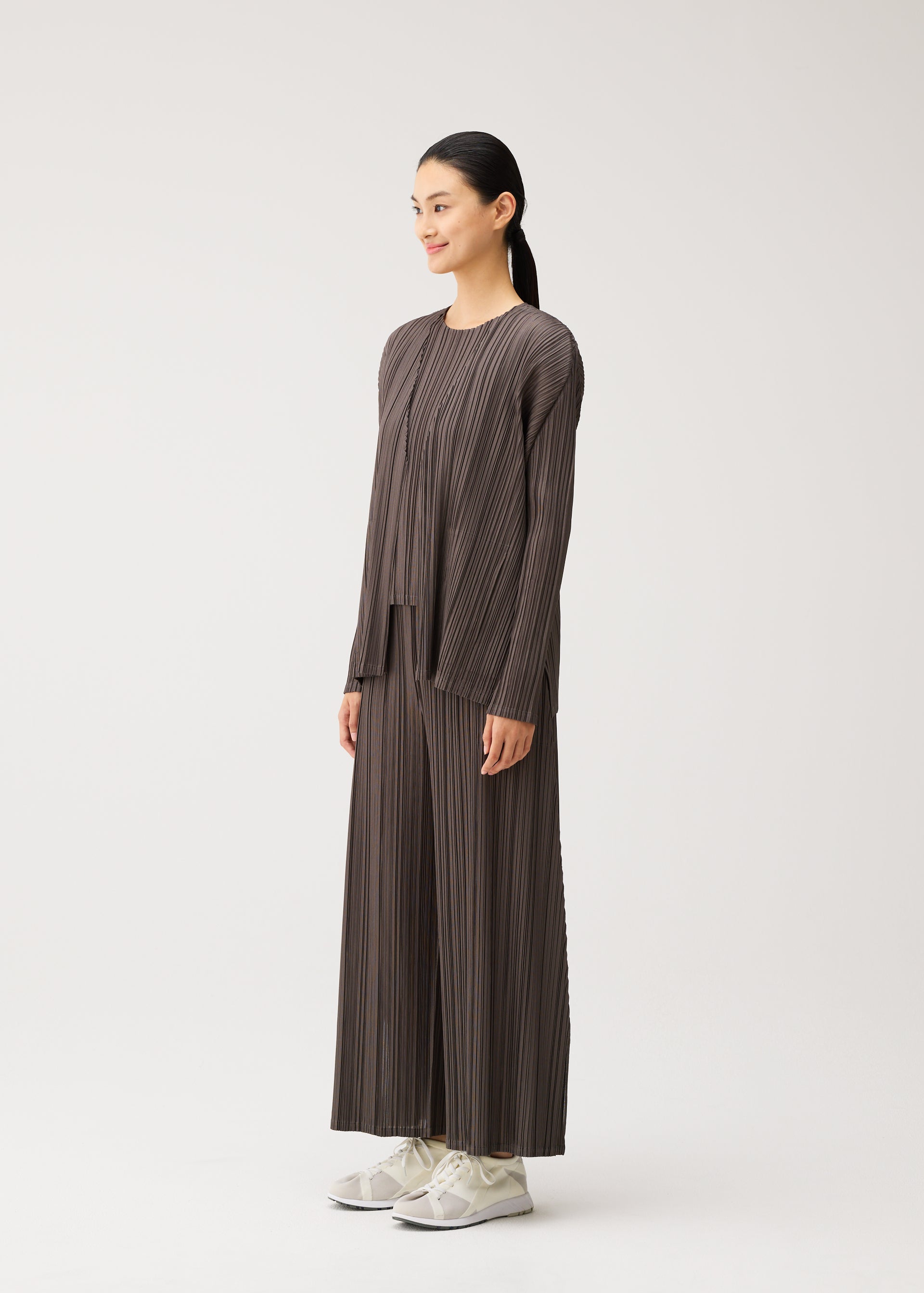 A model wears the PLEATS PLEASE ISSEY MIYAKE MELLOW PLEATS mellow-pleats-cardigan-cerulean-blue.
