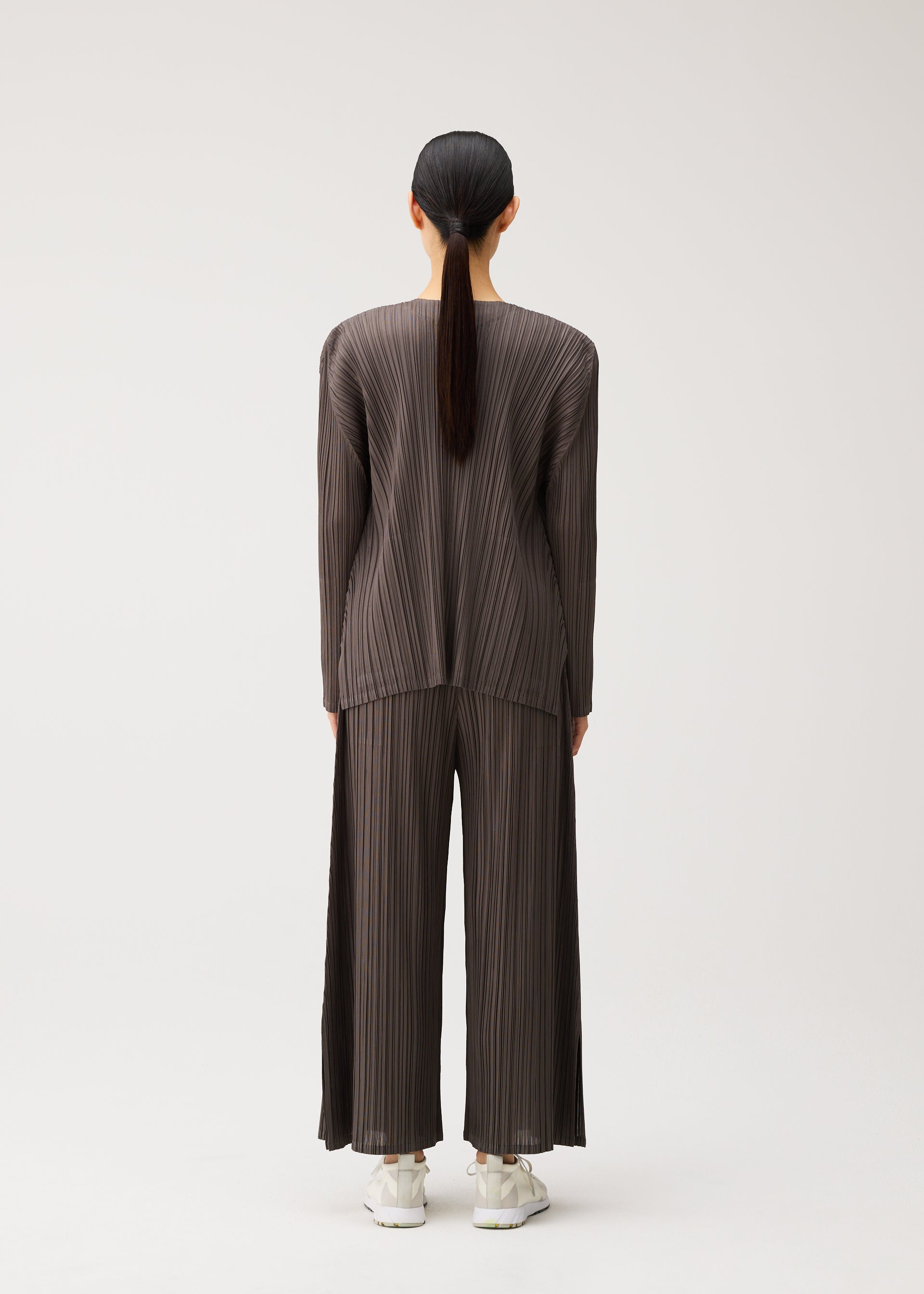 A model wears the PLEATS PLEASE ISSEY MIYAKE MELLOW PLEATS mellow-pleats-cardigan-black.