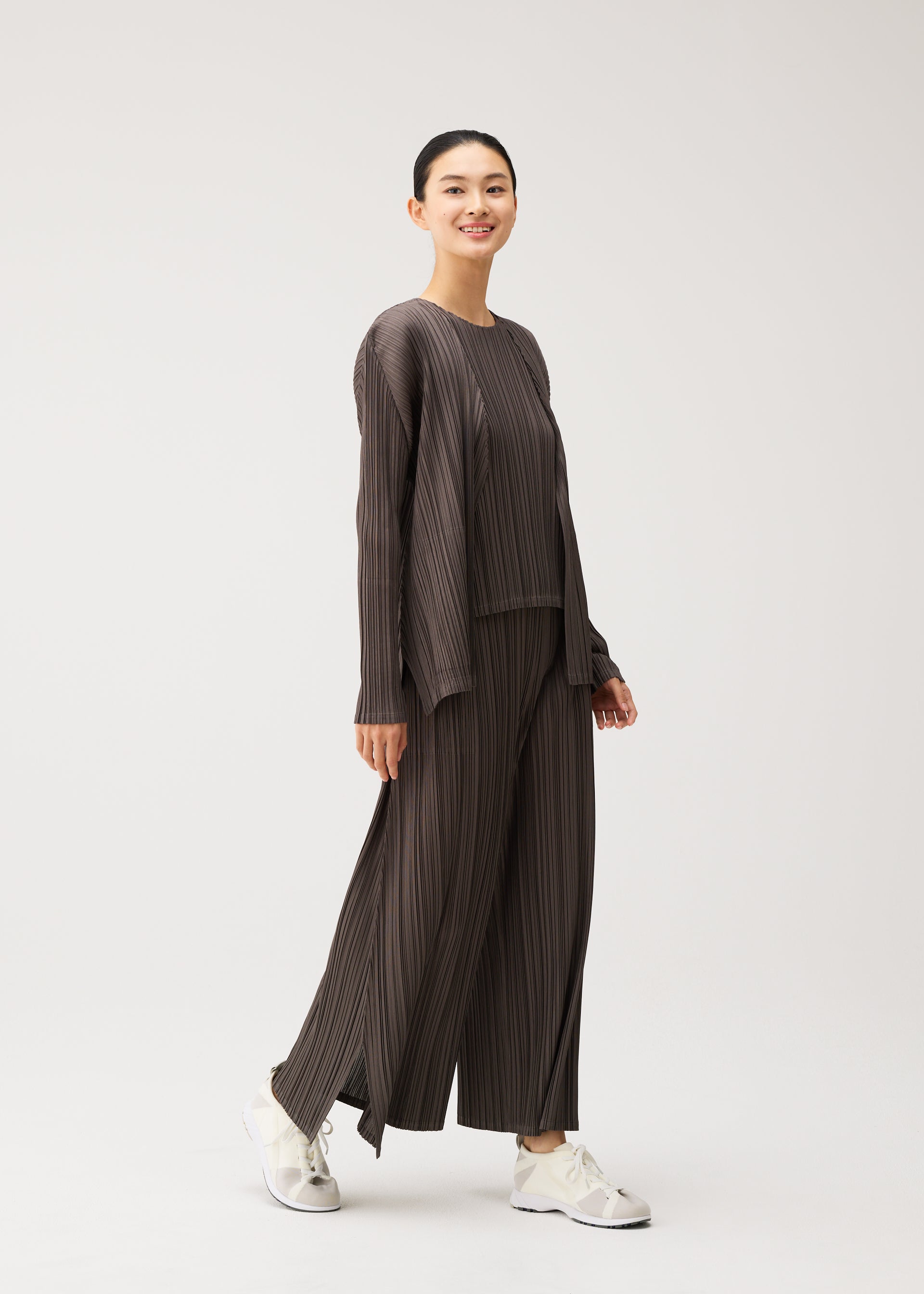 A model wears the PLEATS PLEASE ISSEY MIYAKE MELLOW PLEATS mellow-pleats-cardigan-cerulean-blue.