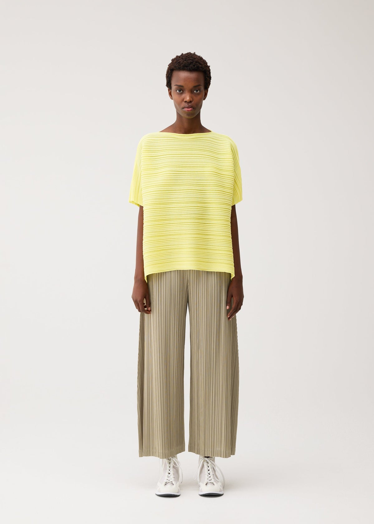 A model wears the PLEATS PLEASE ISSEY MIYAKE PAPER BOUNCE KNIT top.