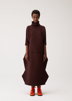 A model wears the PLEATS PLEASE ISSEY MIYAKE ZIG ZAG KNIT zig-zag-knit-top-red.