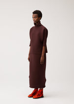 A model wears the PLEATS PLEASE ISSEY MIYAKE ZIG ZAG KNIT zig-zag-knit-top-red.