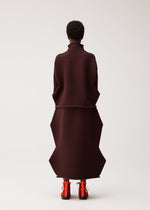 A model wears the PLEATS PLEASE ISSEY MIYAKE ZIG ZAG KNIT zig-zag-knit-top-red.