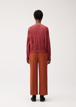 A model wears the PLEATS PLEASE ISSEY MIYAKE SMOOTH COAT smooth-coat-coat-khaki.