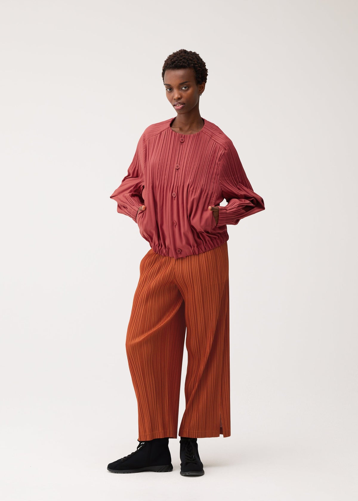 A model wears the PLEATS PLEASE ISSEY MIYAKE SMOOTH COAT smooth-coat-coat-khaki.