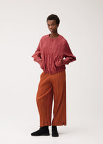 A model wears the PLEATS PLEASE ISSEY MIYAKE SMOOTH COAT smooth-coat-coat-black-2.