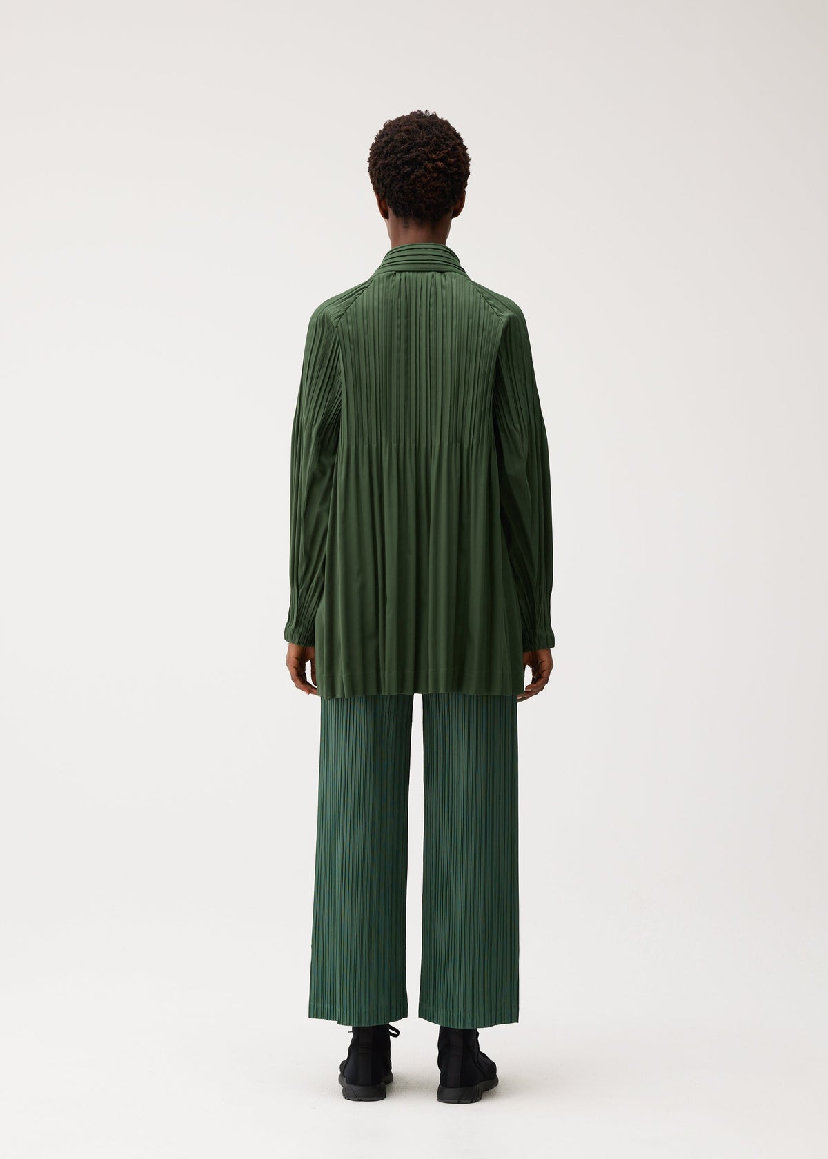 A model wears the PLEATS PLEASE ISSEY MIYAKE SMOOTH COAT smooth-coat-coat-black-3.