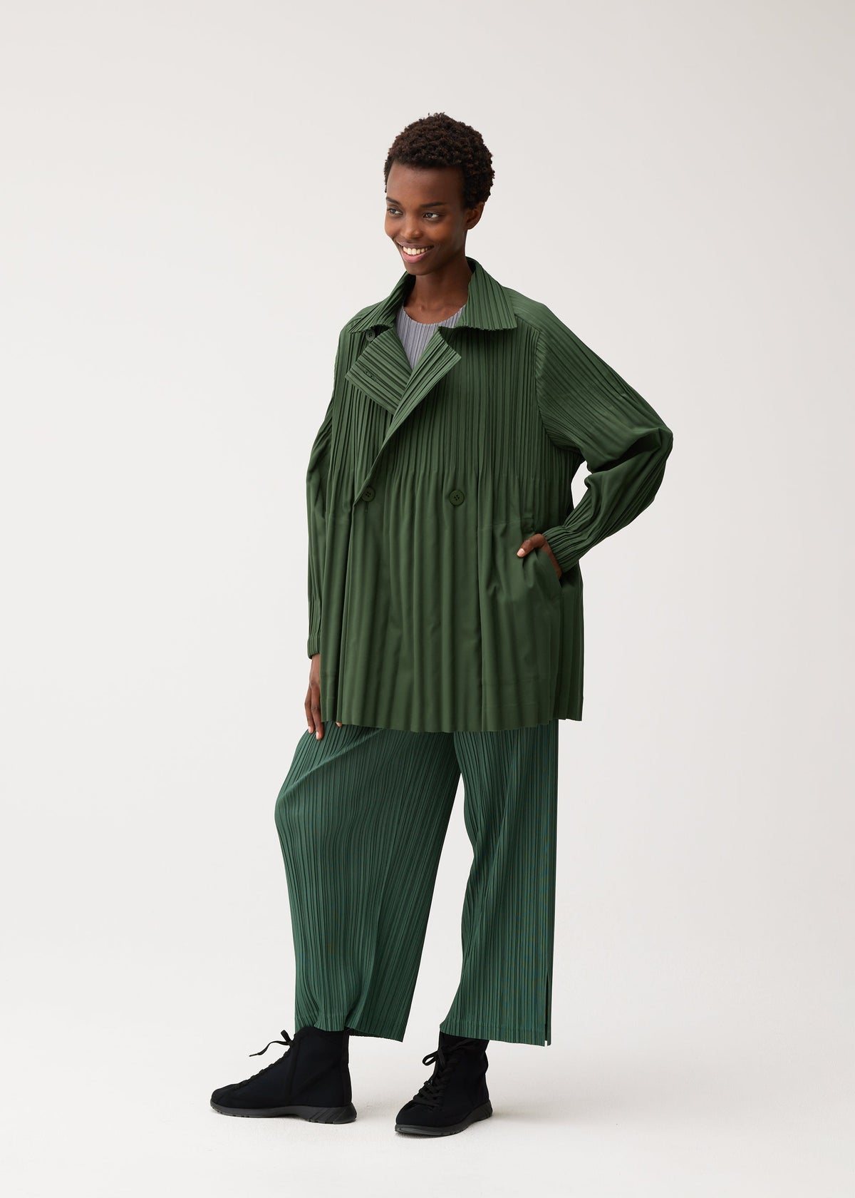 A model wears the PLEATS PLEASE ISSEY MIYAKE SMOOTH COAT smooth-coat-coat-black-3.