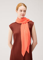 A model wears the PLEATS PLEASE ISSEY MIYAKE MONTHLY SCARF SEPTEMBER monthly-scarf-september-stole-red-brown.