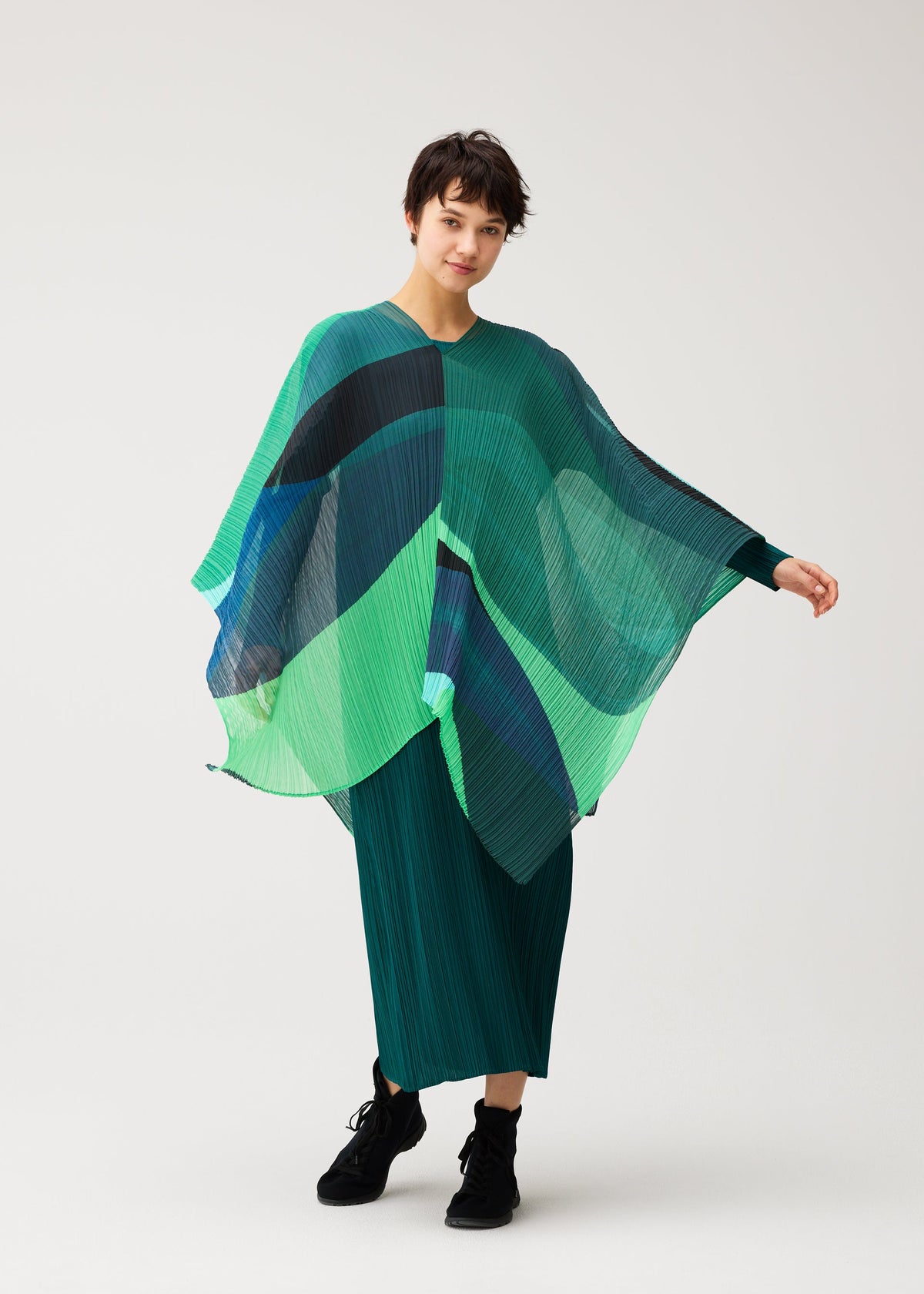 A model wears the PLEATS PLEASE ISSEY MIYAKE ORBIT MADAME-T orbit-madame-t-stole-yellow.