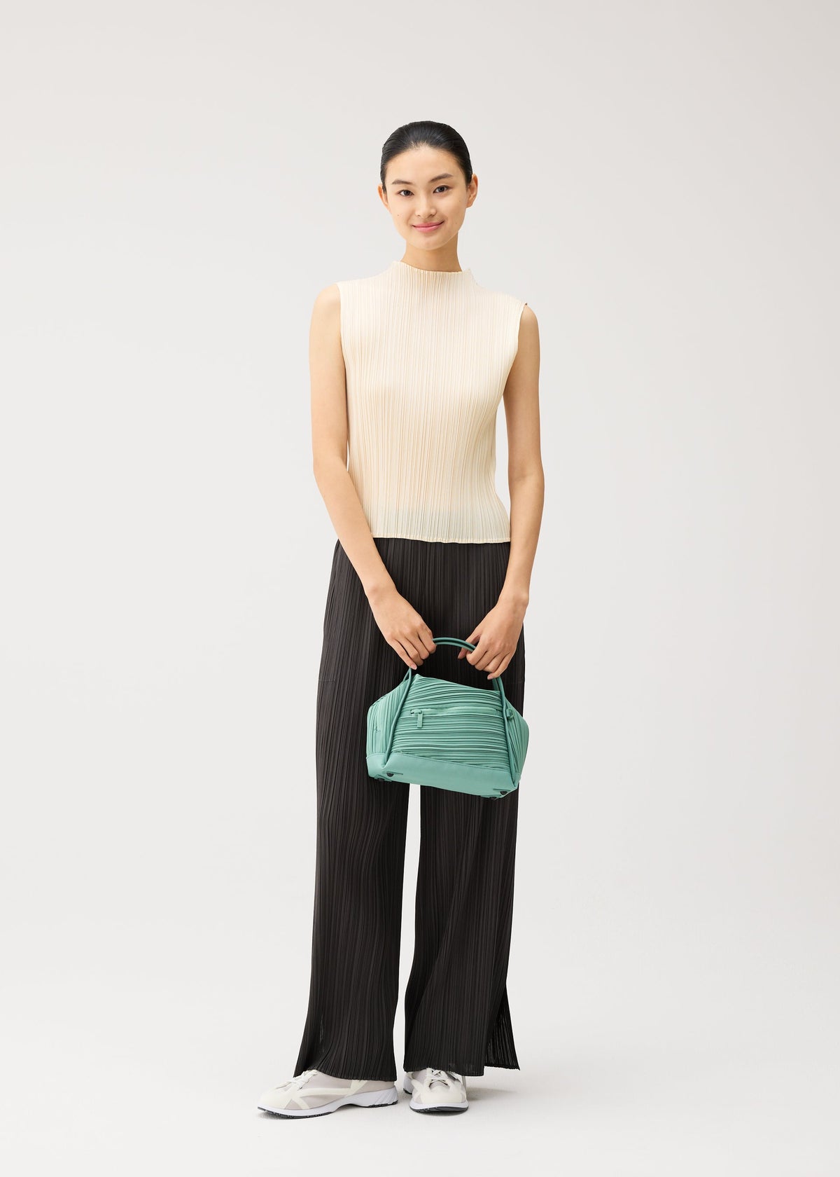 A model wears the PLEATS PLEASE ISSEY MIYAKE BIAS PLEATS BAG bias-pleats-bag-shoulder-bag-light-blue.